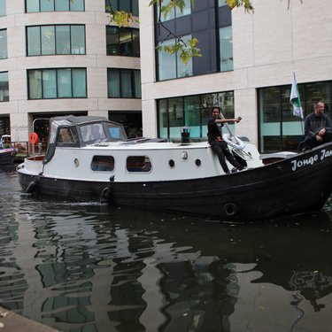 Men steering Jonge Jan along canal