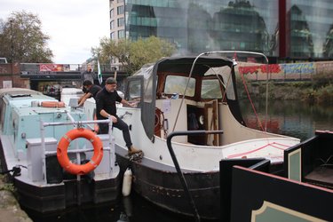 3 Men steering Jonge Jan boat away from canal
