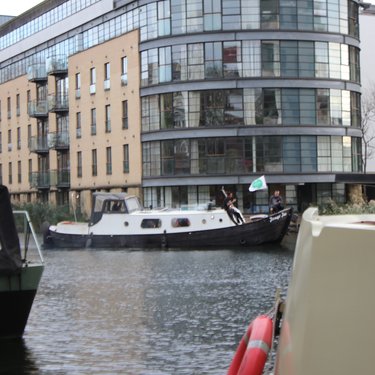 Men steering Jonge Jan along canal