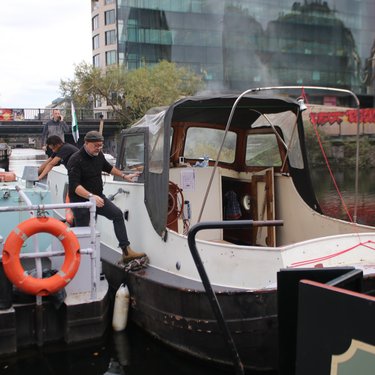 3 Men steering Jonge Jan boat away from canal